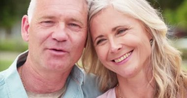 Sevgi dolu yaşlı çift gülümsüyor ve birbirlerine yaslanıyorlar.