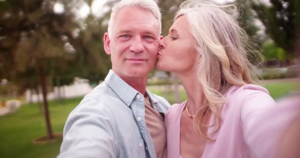 Старша пара в любові цілується і приймає селфі на смартфон — стокове відео