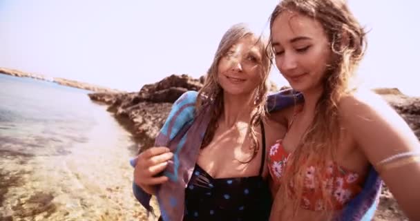Старшие мать и дочь покрыты пляжным полотенцем после купания — стоковое видео