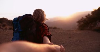 Yaşlı kadın yürüyüşçü kocanın elini tutuyor dağın zirvesine doğru yürüyor.