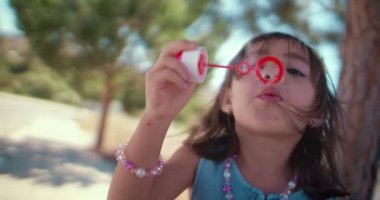 Parkta baloncuk çıkaran küçük Asyalı kız.