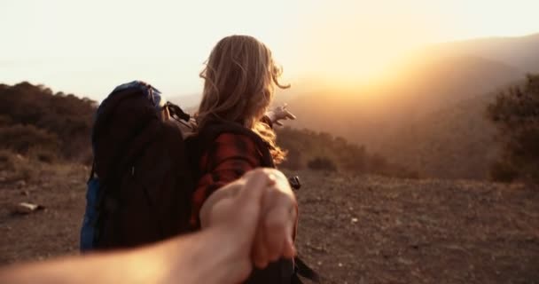 Starší žena držící partnery ruka dosahující vrcholu hory při západu slunce — Stock video
