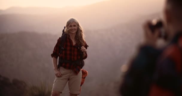 Senior žena turistka fotografoval na vrcholu hory při západu slunce — Stock video