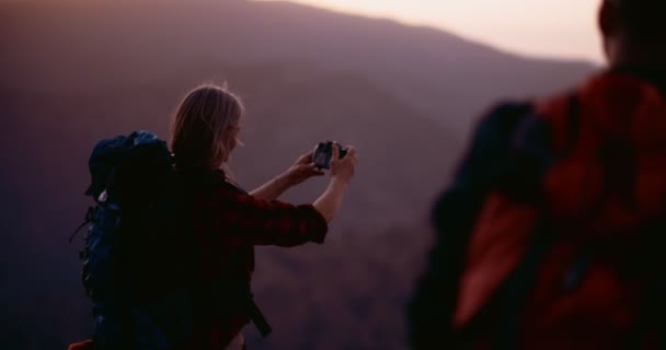 Старша жінка на вершині гори робить панорамні фотографії — стокове відео