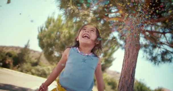 Little Asian girl zabawy z confetti w parku — Wideo stockowe