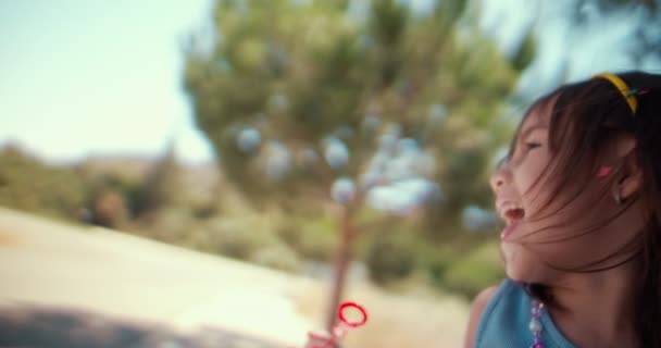 Mignon petit enfant soufflant des bulles au parc en été — Video