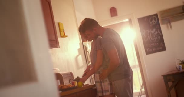 Cariñosa pareja joven preparando el desayuno juntos en la cocina — Vídeo de stock