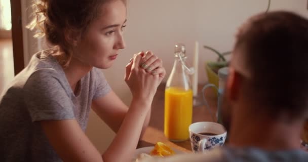 Joven pareja amorosa desayunando juntos en la cocina — Vídeos de Stock