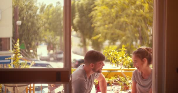 Jeune couple hipster relaxant assis sur balcon appartement urbain — Video