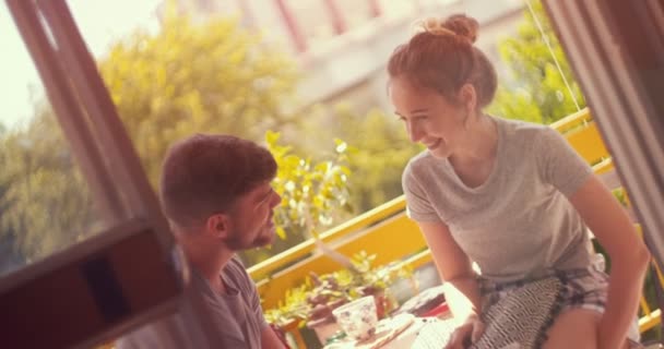 Jeune couple profitant de leur café du matin assis sur un balcon — Video