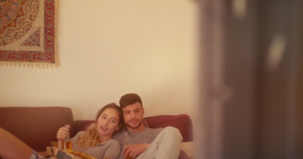 Joven pareja hipster viendo la televisión en casa y relajándose — Vídeos de Stock