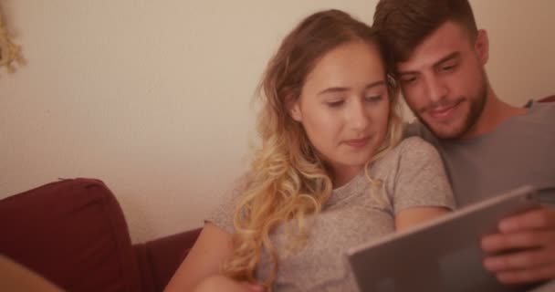 Evde dijital tablet kullanan genç hippi çift. — Stok video