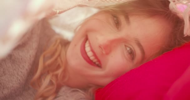 Romantische jonge vrouw liggend onder het bed covers — Stockvideo