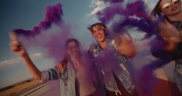 Amigos adolescentes divirtiéndose con bombas de humo en el área rural — Vídeo de stock