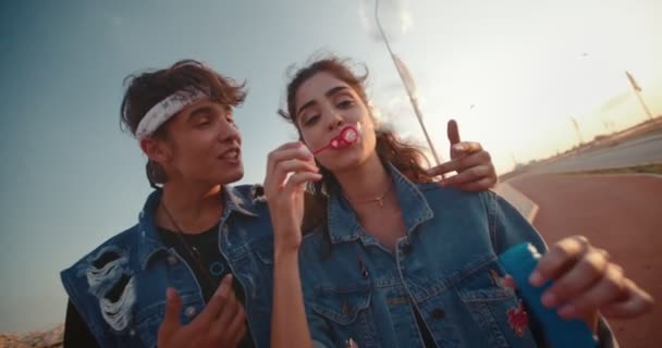 Hipster nastolatek chłopak i dziewczyna mając zabawy dmuchanie pęcherzyki — Wideo stockowe