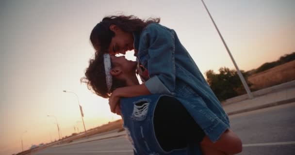 Hipster-Freund holt Mädchen bei Sonnenuntergang auf der Straße ab — Stockvideo