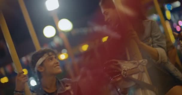 Adolescente pareja besándose en parque de atracciones carrusel paseo — Vídeo de stock