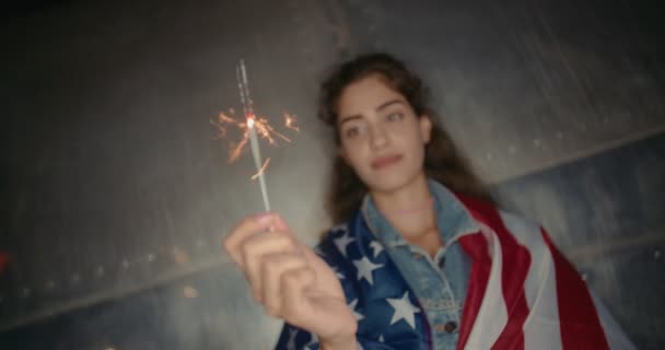 Mulher com bandeira americana e faíscas comemorando o quarto de julho — Vídeo de Stock