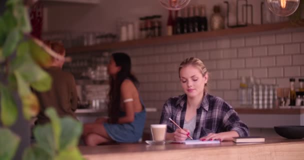 Ung kvinnlig konstnär ritar på modernt kafé — Stockvideo