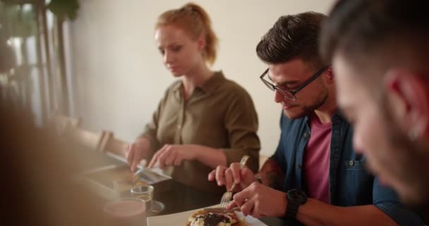 Genç hippi arkadaşlar modern kafede kahvaltı yapıyorlar. — Stok video