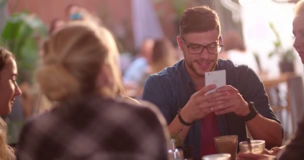 Ευτυχισμένος hipster άνθρωπος γραπτών μηνυμάτων στο smartphone, ενώ σε ένα καφέ — Αρχείο Βίντεο