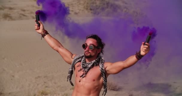 Jovem com bombas de fumaça comemorando no festival de música do deserto — Vídeo de Stock