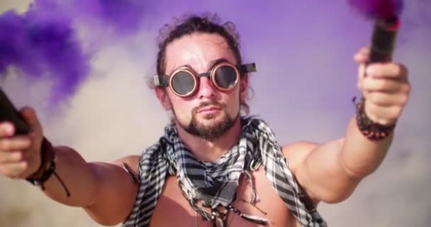 Junger Mann mit Steampunk-Brille und Rauchbomben in der Wüste — Stockvideo