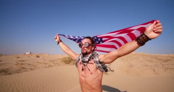 Uomo con occhiali steampunk e bandiera americana che corre nel deserto — Video Stock