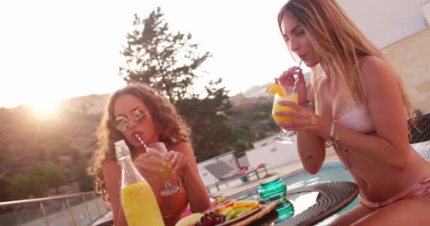 Multi-etniske kvinnelige venner i bikini spiser frokost ved bassenget – stockvideo