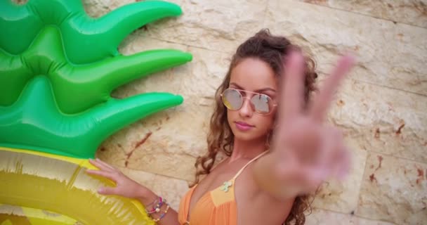 Young brazilian woman with summer inflatable making a peace sign — Stock Video