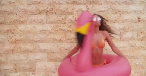 Mujer bronceada girando con flamenco inflable y goma de mascar soplante — Vídeos de Stock