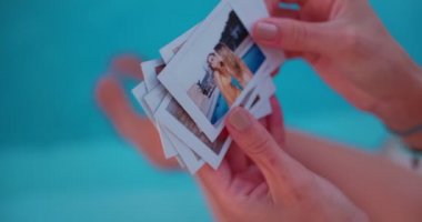 Yaz anılarına bakan genç bir kadın havuz başında anlık fotoğraflar çekiyor.