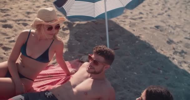 Amigos en trajes de baño tumbados al sol en la playa — Vídeos de Stock