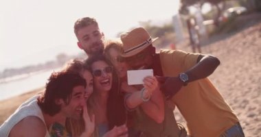 Çok ırklı hipster arkadaşlar yazın sahilde selfie çekiyorlar.