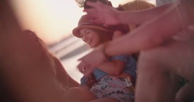 Çok ırklı hippi çift plaj partisinde arkadaşlarıyla eğleniyor.