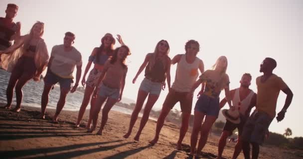 Junge multiethnische Freunde springen in den Sommerferien am Strand — Stockvideo