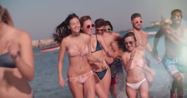 Молоді багатоетнічні друзі на літні канікули біжать на пляжі — стокове відео