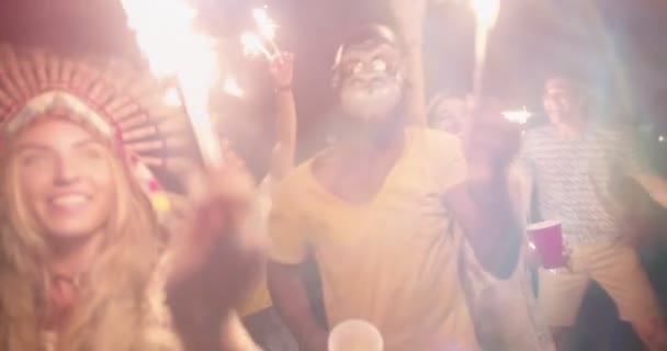 Young multi-ethnic hipster friends partying with fireworks at night — Stock Video