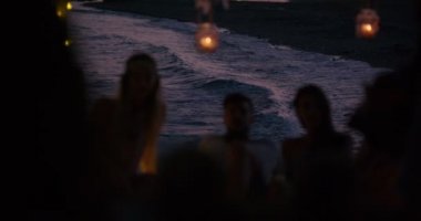 Gençler deniz kenarındaki yazlık barda dinleniyorlar.