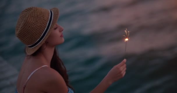 Young woman on summer holidays holding sparklers at the sea — Stock Video