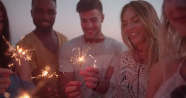 Junge multiethnische Hipster-Freunde feiern mit Wunderkerzen auf Dachparty — Stockvideo