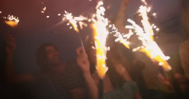 Jóvenes hipsters multiétnicos celebrando con fuegos artificiales en la fiesta nocturna — Vídeos de Stock