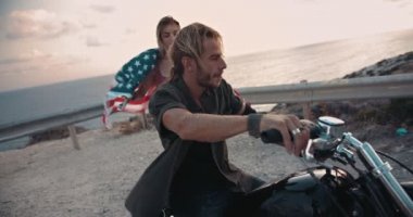Amerikan bayrağı taşıyan bisikletli çift yola koyuluyor.