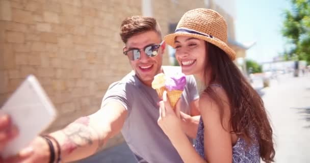 Joven pareja hipster tomando selfies y comiendo helado en verano — Vídeos de Stock