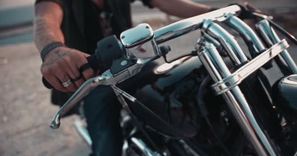 Zbliżenie macho mans ręce z tatuażami na kierownicy motocykla — Wideo stockowe