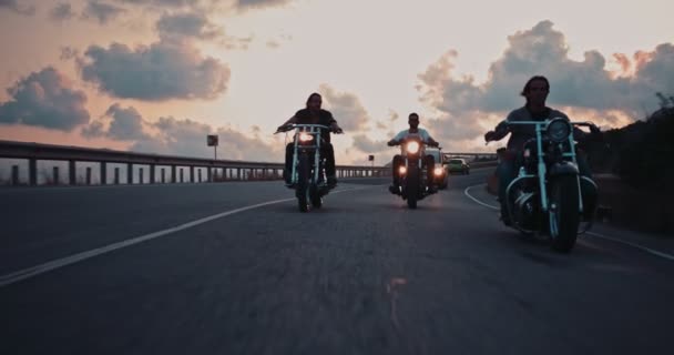 Jóvenes ciclistas masculinos montando motocicletas en la carretera al atardecer — Vídeo de stock