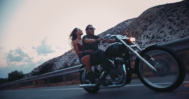 Motociclista rebelde con novia montando moto en carretera — Vídeo de stock