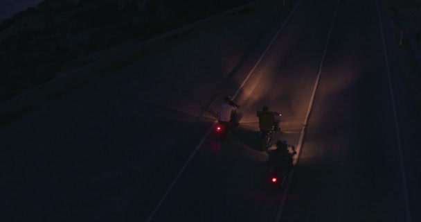 Aerial view of motorcyclists riding motorbikes at night — Stock Video