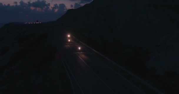 Vue par drone des motocyclistes conduisant des motos sur l'autoroute la nuit — Video