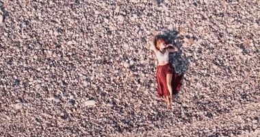 Yazın plajda uzanan boho tarzı bir kadın.